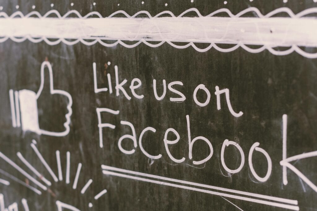 Chalkboard drawing with a thumbs-up and the words "Like us on Facebook" written in white. | Tsunami Reach