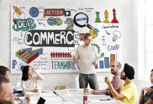 A group discusses ideas in front of a large, colorful "Commerce" brainstorming board in a modern office. | Tsunami Reach