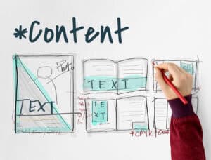 A hand sketches website content layout ideas with notes, drawings, and the word "Content" written at the top. | Tsunami Reach