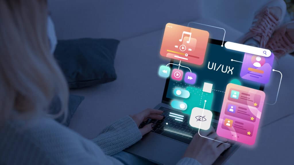 Person using a laptop with colorful, floating UI/UX digital interface elements over the screen. | Tsunami Reach