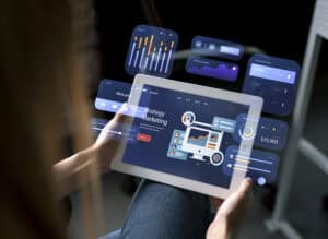Person holding a tablet displaying digital marketing strategy graphics, surrounded by AI tools and analytics charts. | Tsunami Reach