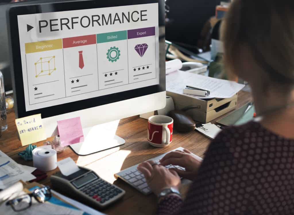 Person typing at desk, viewing a computer screen showing a performance rating chart with four skill levels. | Tsunami Reach
