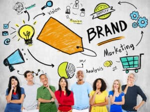A diverse group of people stands under colorful brand-related doodles, including a tag, lightbulb, and marketing icons. | Tsunami Reach