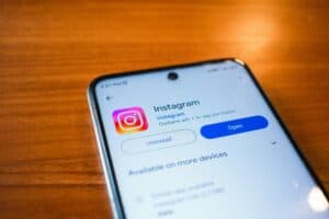 A smartphone screen shows the Instagram app page with options to uninstall or open the app. | Tsunami Reach