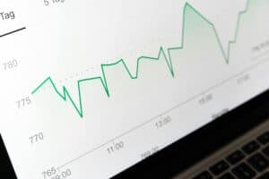 A green line graph on a computer screen shows fluctuating data points over time. | Tsunami Reach