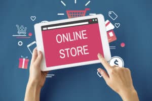 Hands holding a tablet displaying "ONLINE STORE," highlighting digital marketing for online stores in the background. | Tsunami Reach