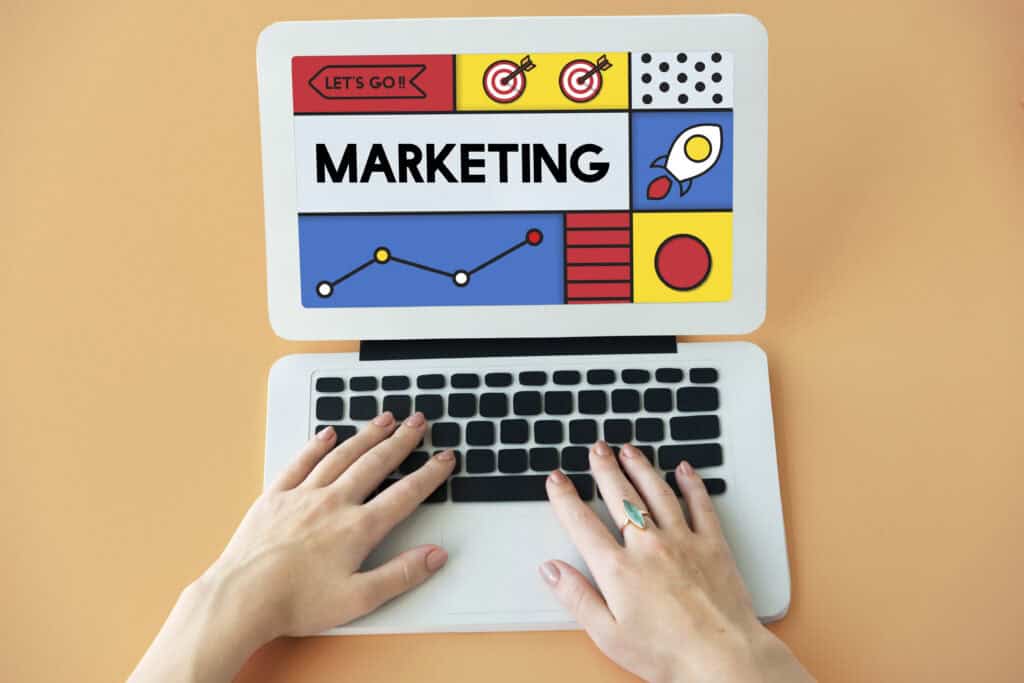 Hands on a laptop keyboard with a screen displaying colorful SEO content marketing graphics and charts. | Tsunami Reach