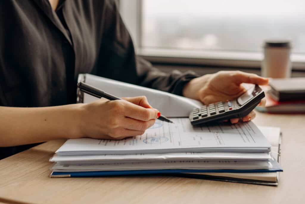 A person calculating paid advertising fees. | Tsunami Reach